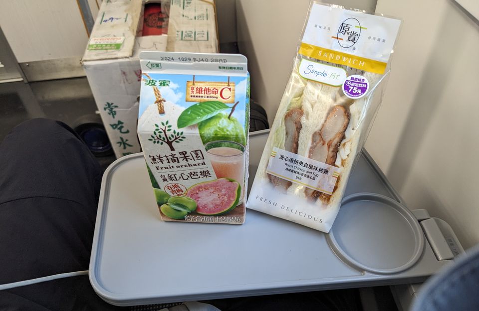 超商買的三明治跟芭樂汁，擺在列車上的桌子